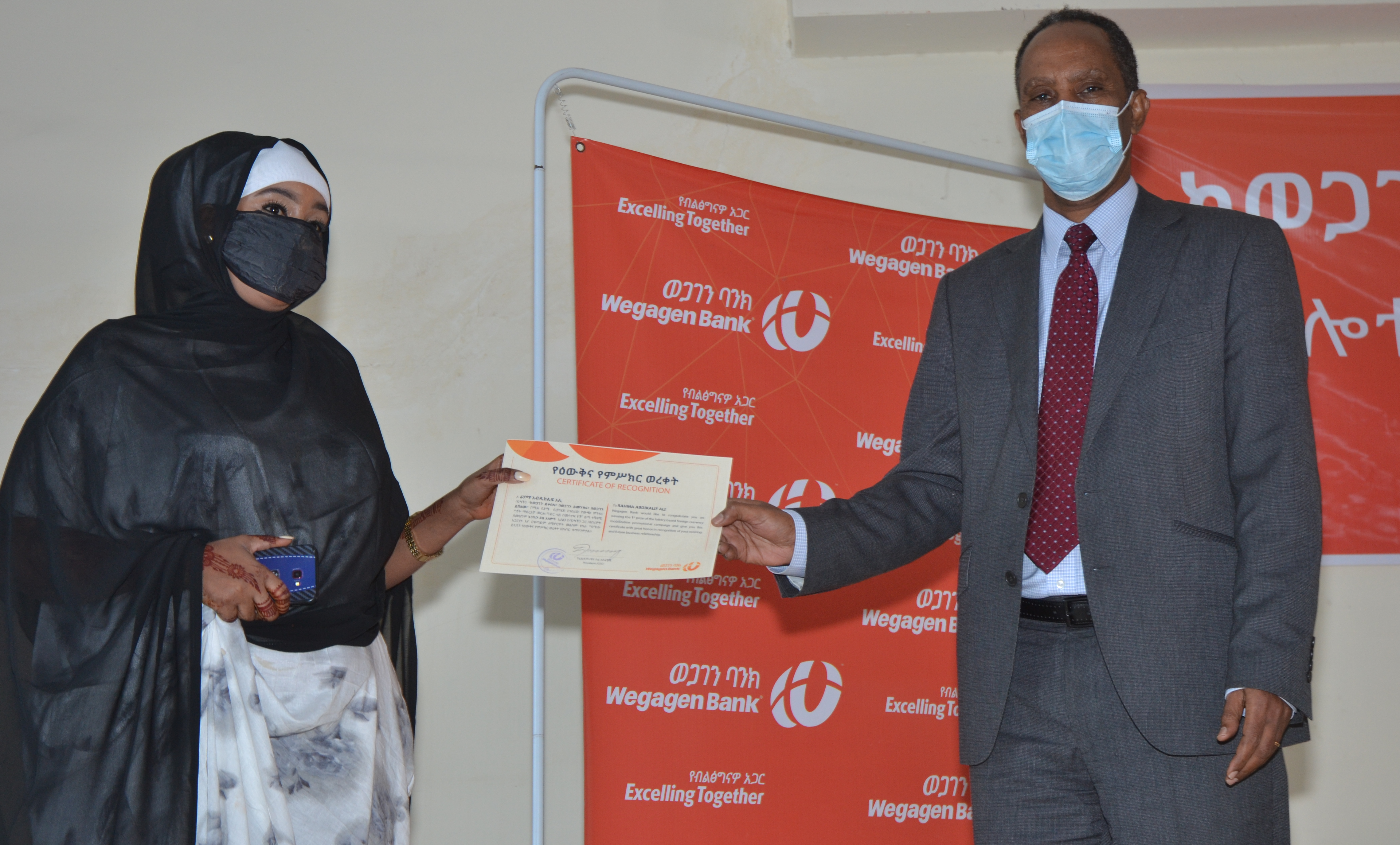 CEO handing over certificate to Rahama Abdi,first rank prize (Kia 2019 Model Automobile) Winner .